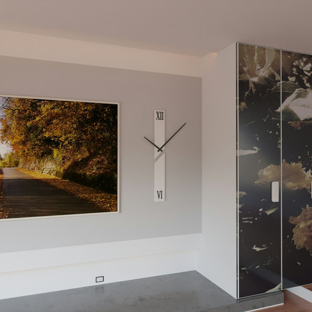 Horloge murale au design épuré entre un cadre et un meuble
