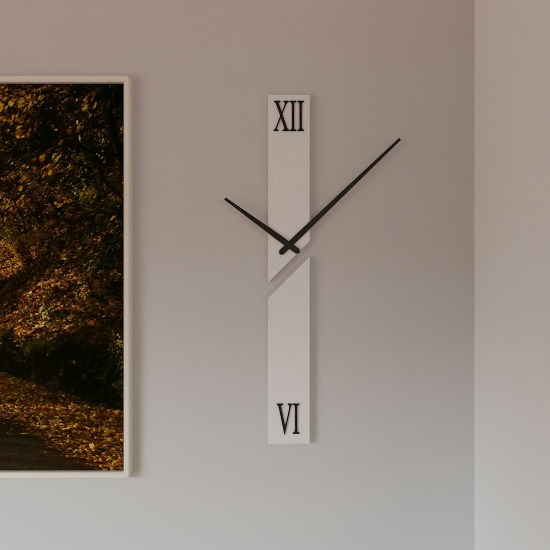 Horloge murale minimaliste accrochée près d'un cadre décoratif